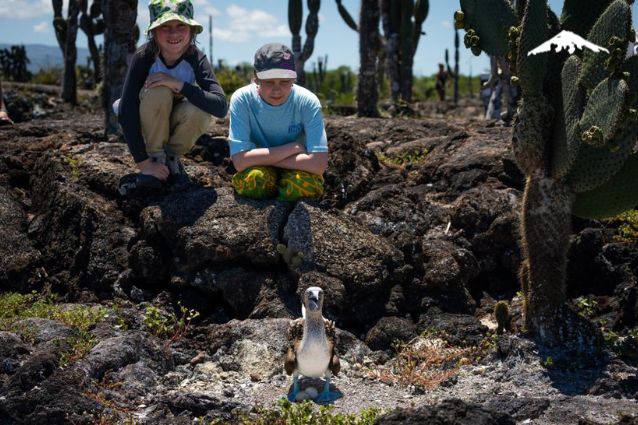 Guests with blue-footed booby at Los Túneles in Isabela Island.