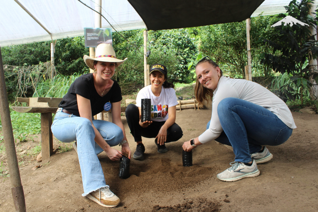 The Rebecca Adventure Travel team and Leticia, the coffee farm owner, plant coffee seedlings in Medellin.