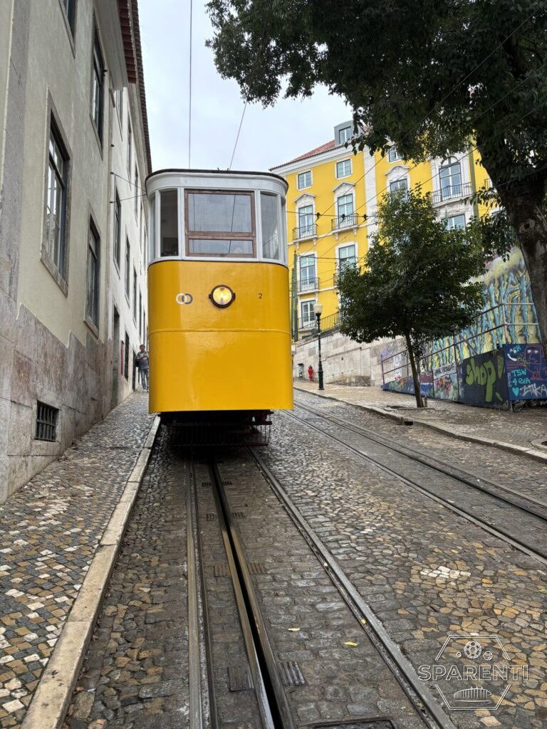 De gele tram in een steile straat in Lissabon